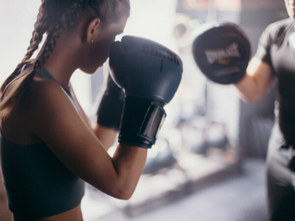 Sports coach during boxing training with a girl