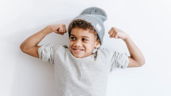 Child with hat poses with his 'muscle' for power kids